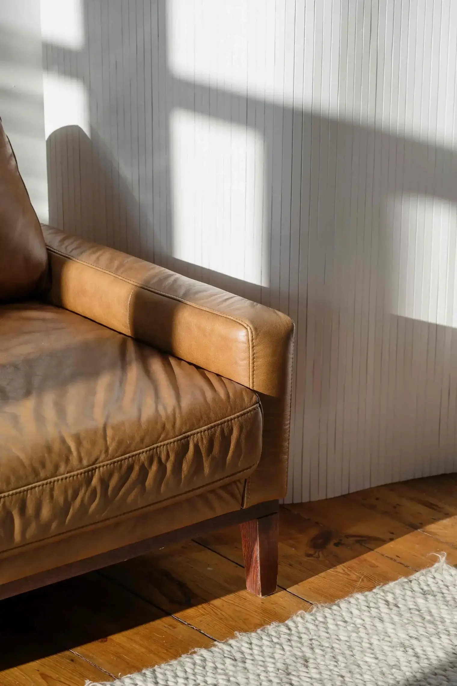 Made bed resting beside a bright curtained window and soft daylight inside an Ivory on Long Creek apartment bedroom.