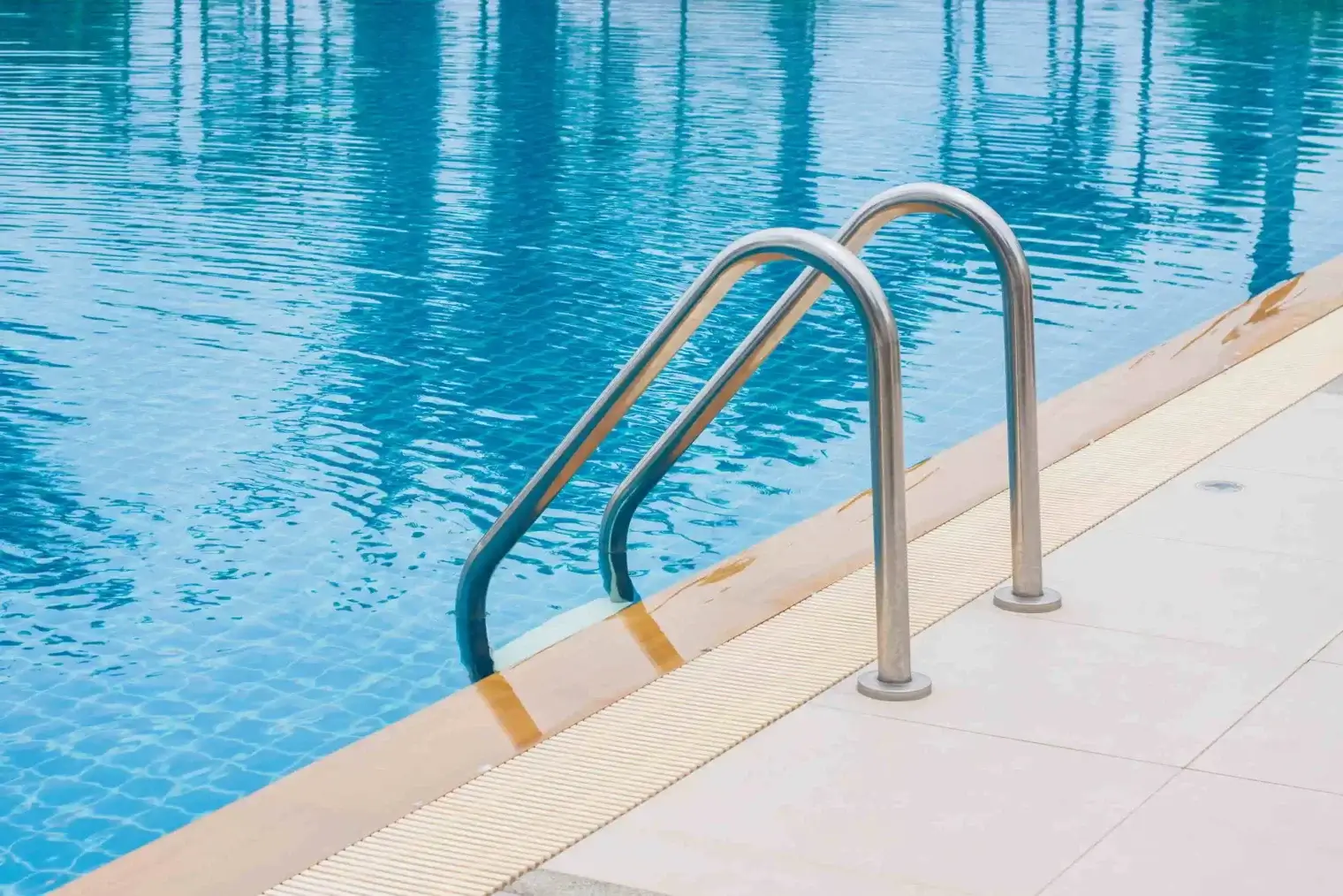Sparkling swimming pool meeting a chrome handrail and a paved sun deck at Ivory on Long Creek in Gastonia, NC.