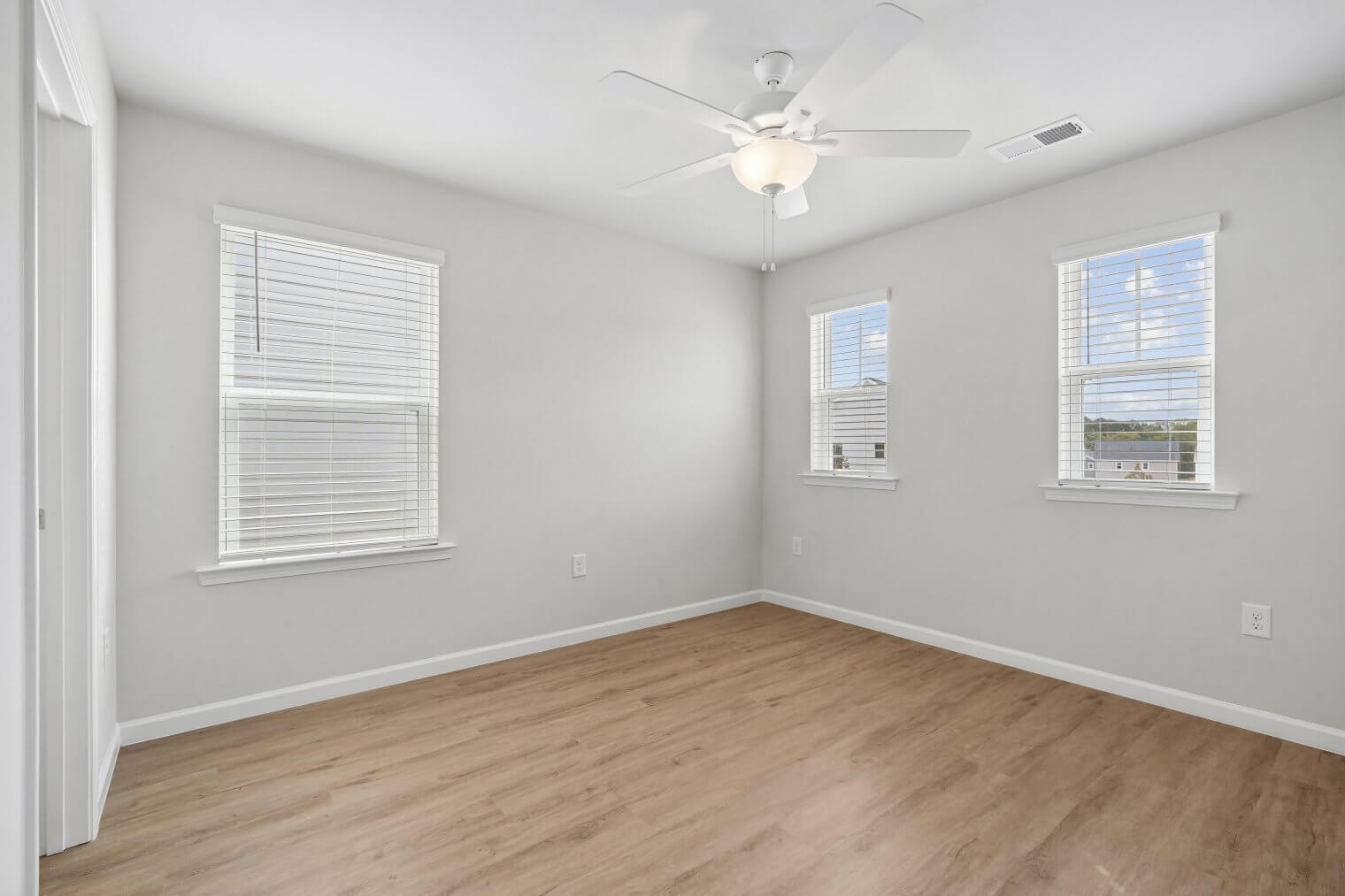 bright open bedroom with wood inspired floors