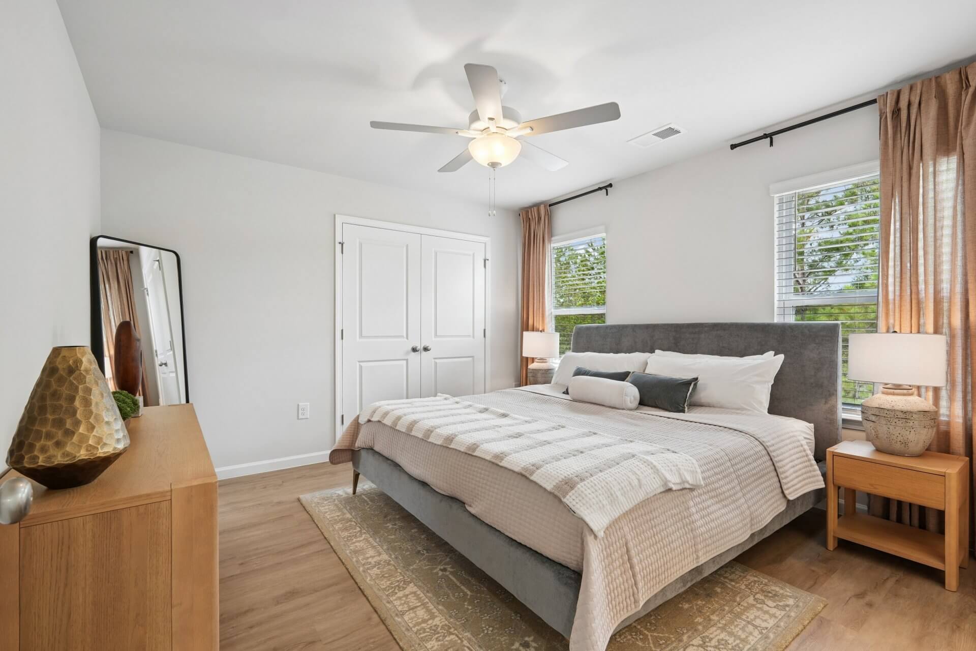 spacious bedroom with large bed dresser and night stands