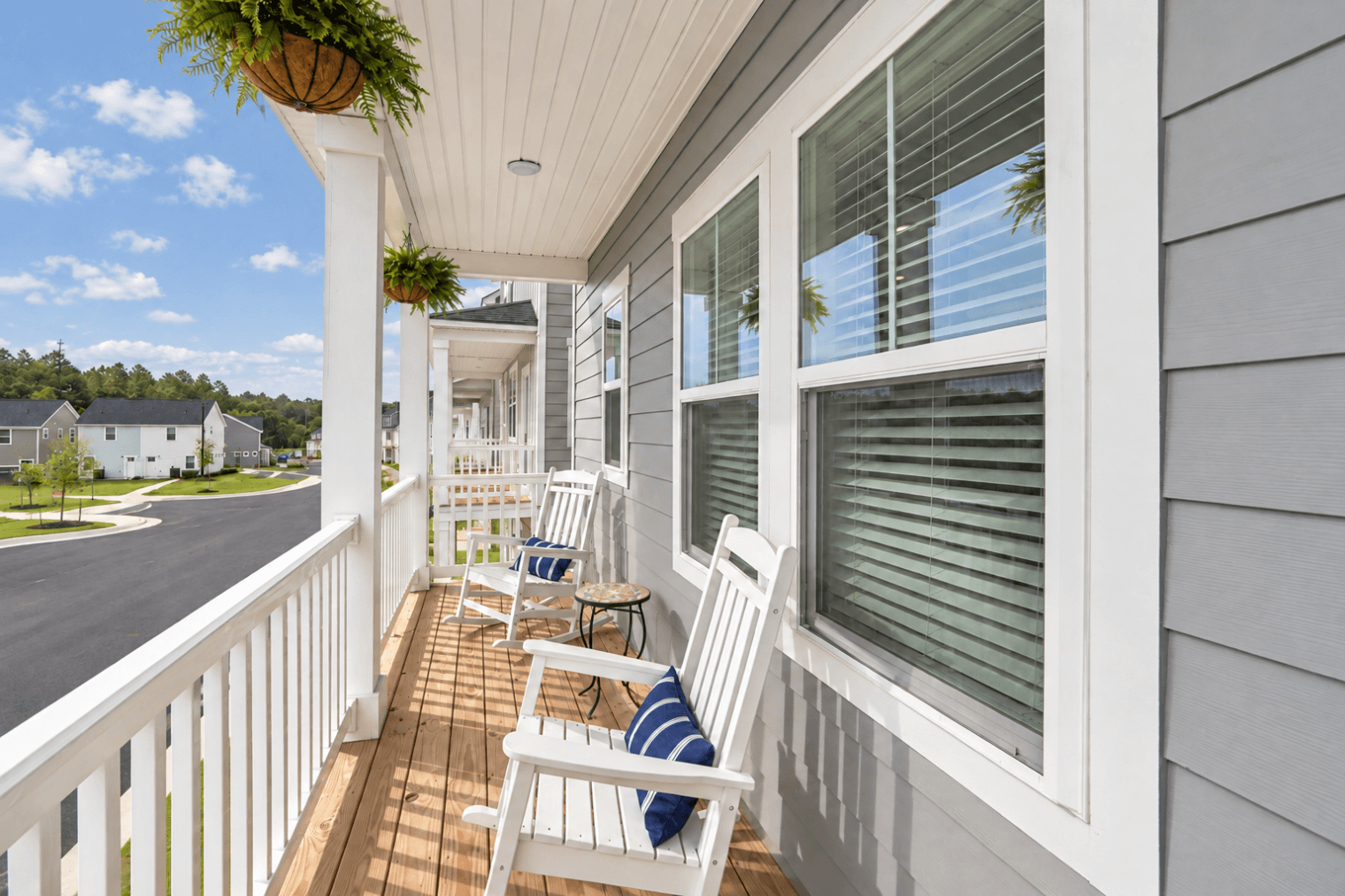 sunlit porch with rocking chairs and ferns